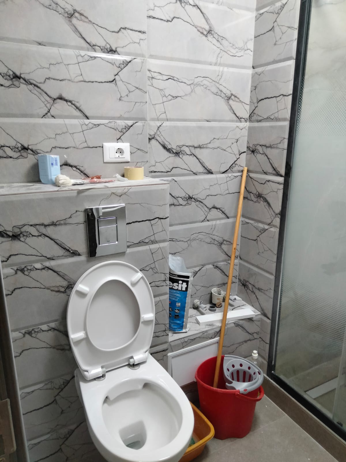Baie finalizată, cu faianță aspect marmură și vas WC suspendat
