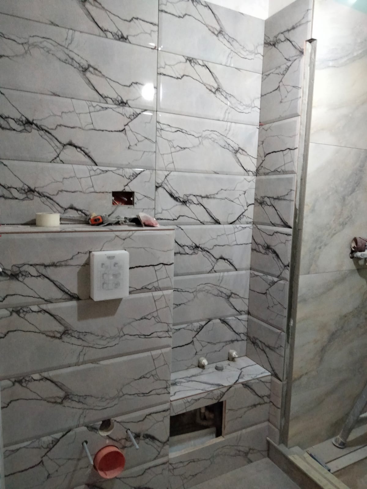Baie placată cu faianță aspect marmură, zona de duș