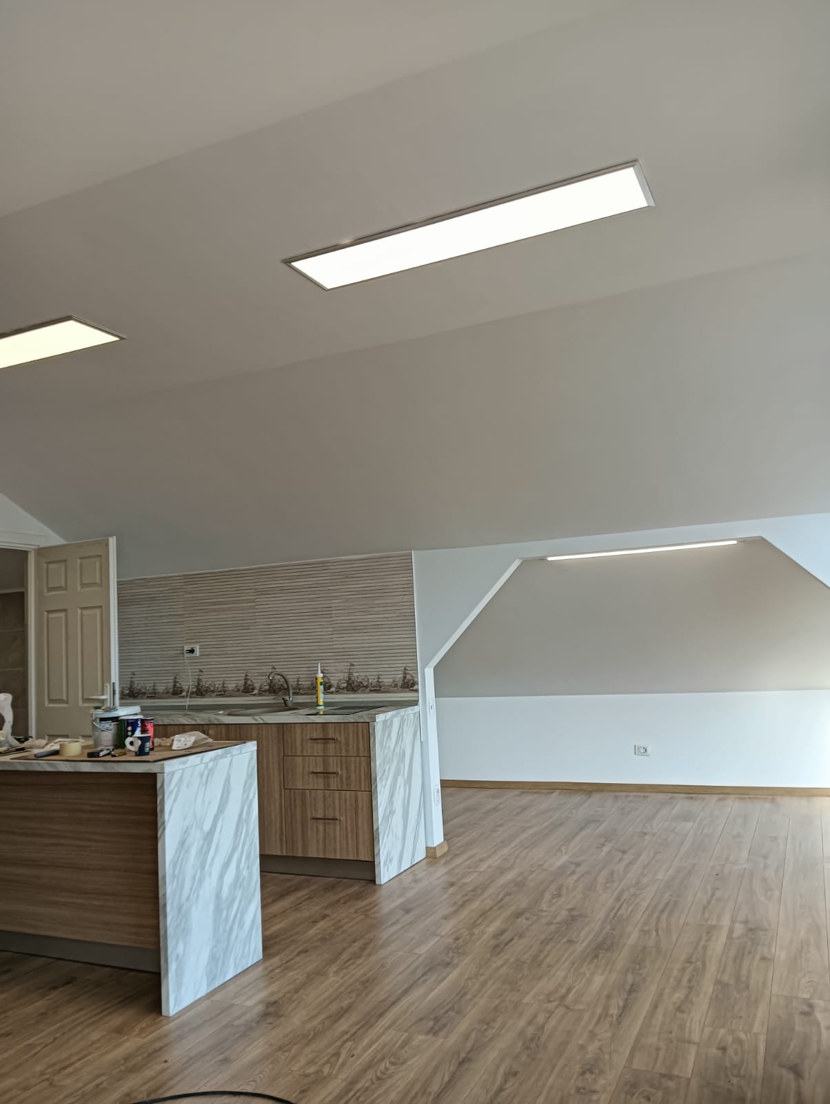 Bucătărie deschisă spre living, cu iluminat LED încastrat